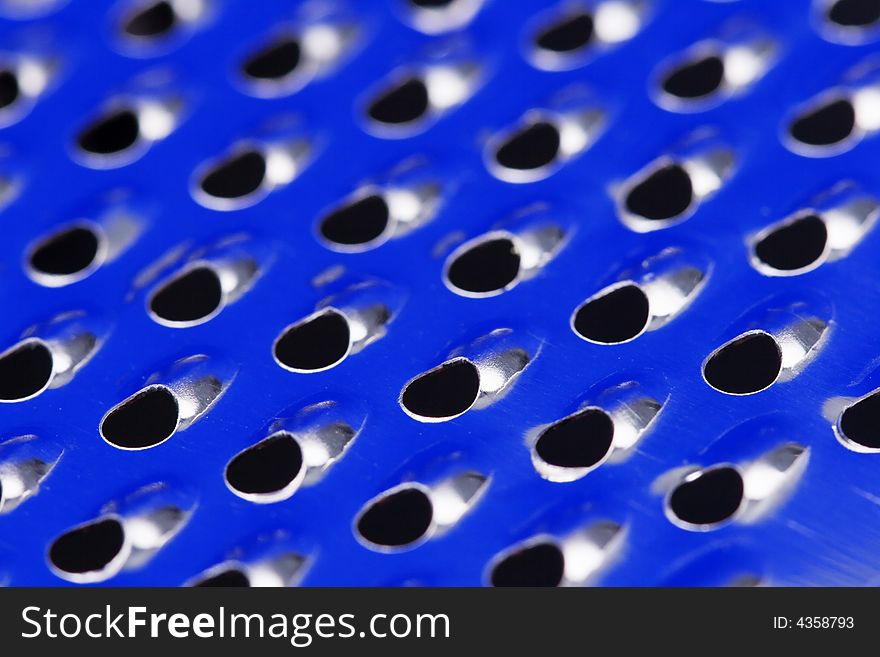 Close up of a stainless steel grater with blue reflection. Close up of a stainless steel grater with blue reflection