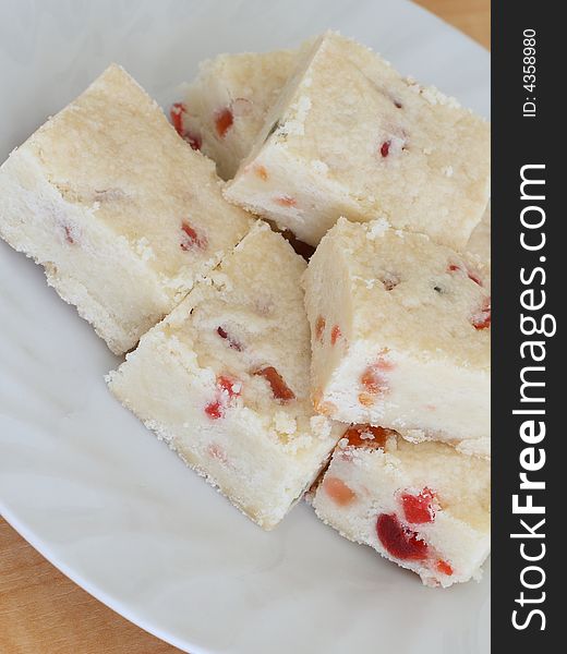 Several pieces of shortbread with candied fruit on a plate