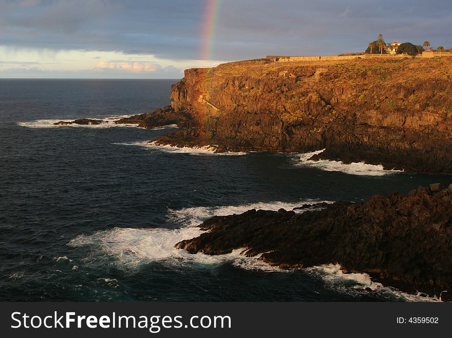 Rocky sea coast with rainbow. Rocky sea coast with rainbow