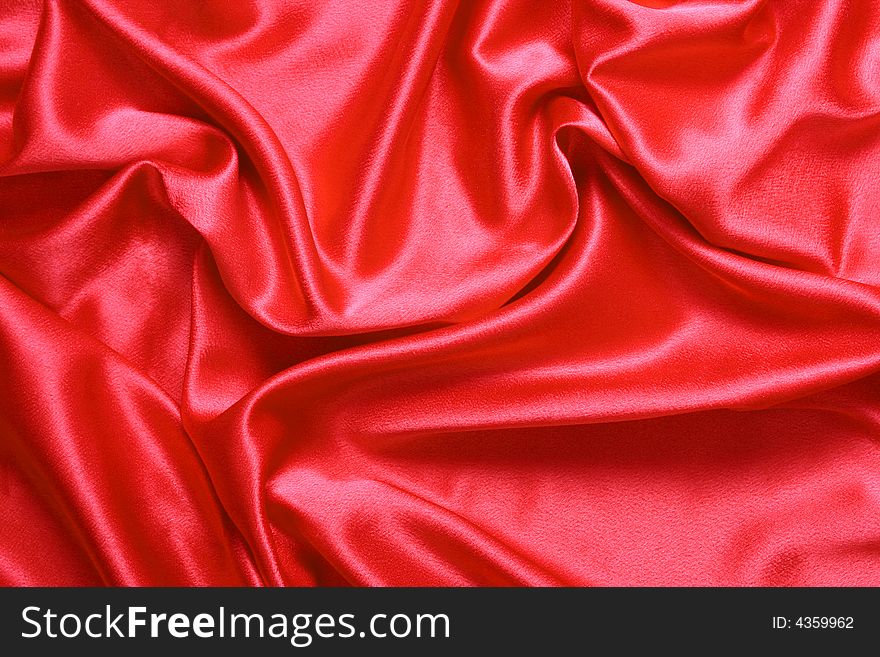 Background. Red satin fabric with folds. Background. Red satin fabric with folds