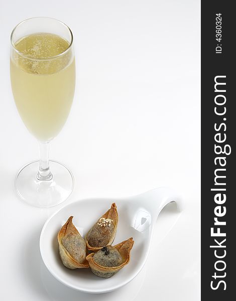 A glass of champagne with finger food