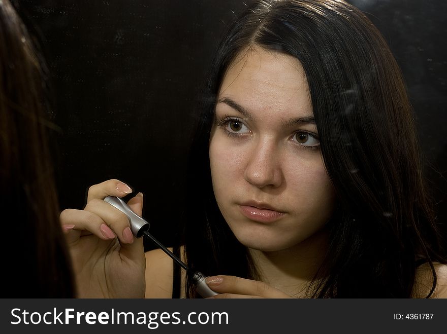 Young girl putting on makeup. Young girl putting on makeup