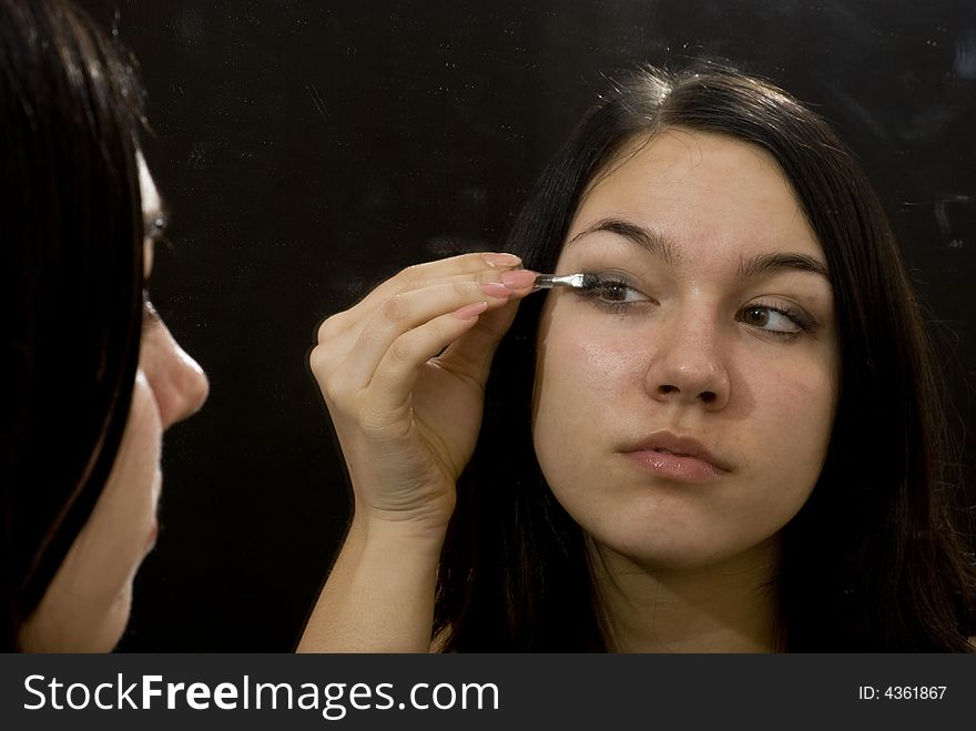 Girl putting on her makeup. Girl putting on her makeup