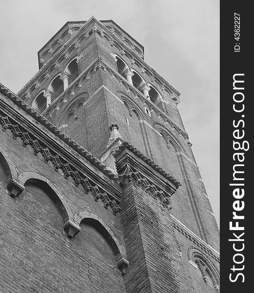 Religion and architecture: looking up view of a brick church tower in black and white