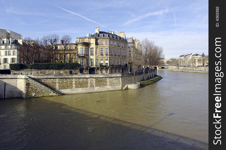 France, Paris: nice city view from the quai of the seine river; blue sky; naked trees and the river tranquility for this winter view of Paris. France, Paris: nice city view from the quai of the seine river; blue sky; naked trees and the river tranquility for this winter view of Paris