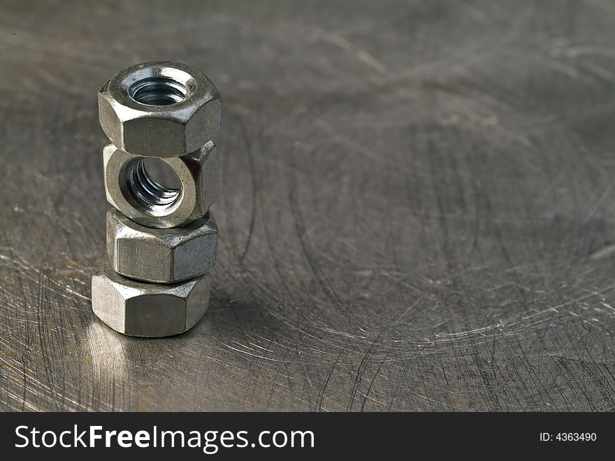 Tower of balanced nuts on metallic background. Tower of balanced nuts on metallic background