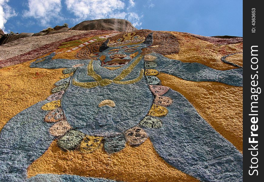 This is a tibetan buddhism joss carved in a huge rock more than six metres high. A trail of death's-heads is hung on its body. From this you can see what a terrible religion the Tibetan Buddhism is.