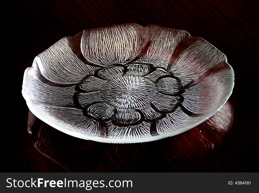 A crystal-like lotus shaped glass plate with engraved patterns, shiny and transparent. A crystal-like lotus shaped glass plate with engraved patterns, shiny and transparent.