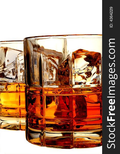 Close-up of liquor and ice in glasses on an isolated white background. Close-up of liquor and ice in glasses on an isolated white background.