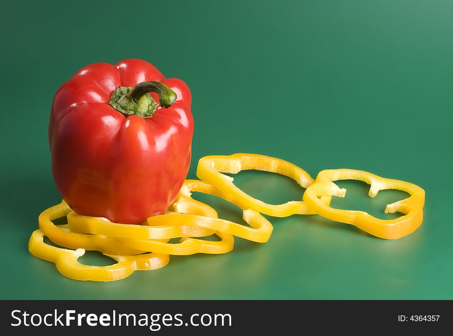 Red and yellow peppers over green background