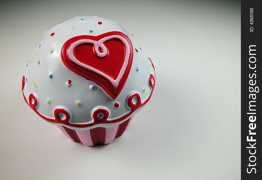 A plastic Valentines cup cake with a cartoon style heart and stripes shot with macro lens