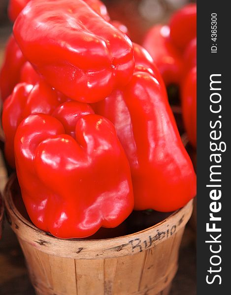 Red bell peppers for sale in a basket on a open air market stall. Red bell peppers for sale in a basket on a open air market stall