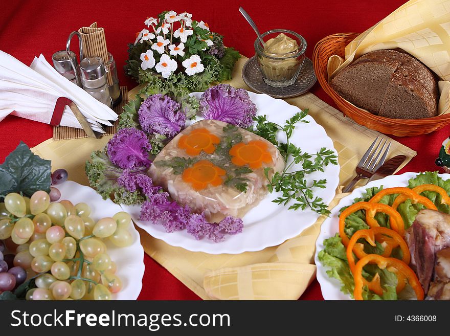 Celebratory table with meat products, fruit, vegetables and greens