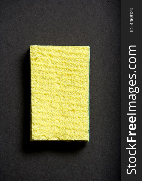 A yellow sponge on a black background