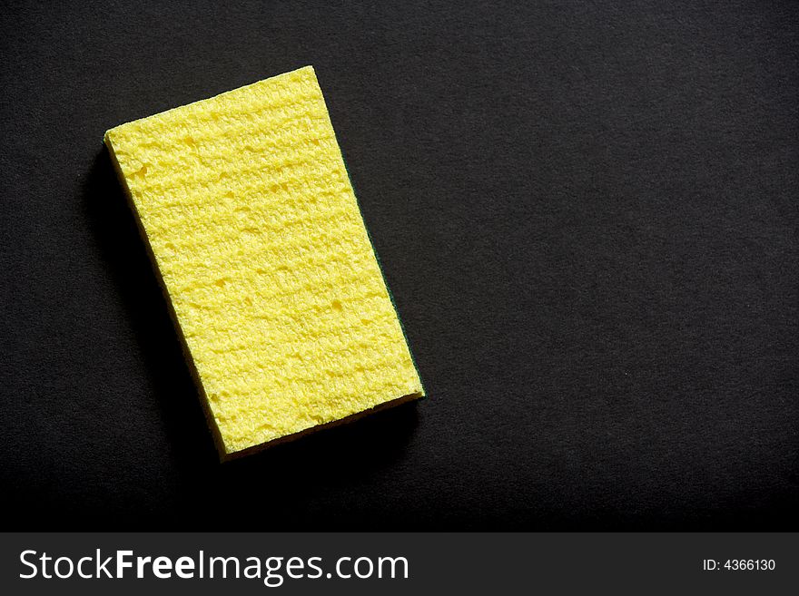 A yellow sponge on a black background