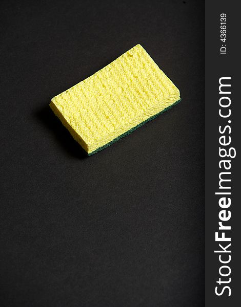 A yellow sponge on a black background