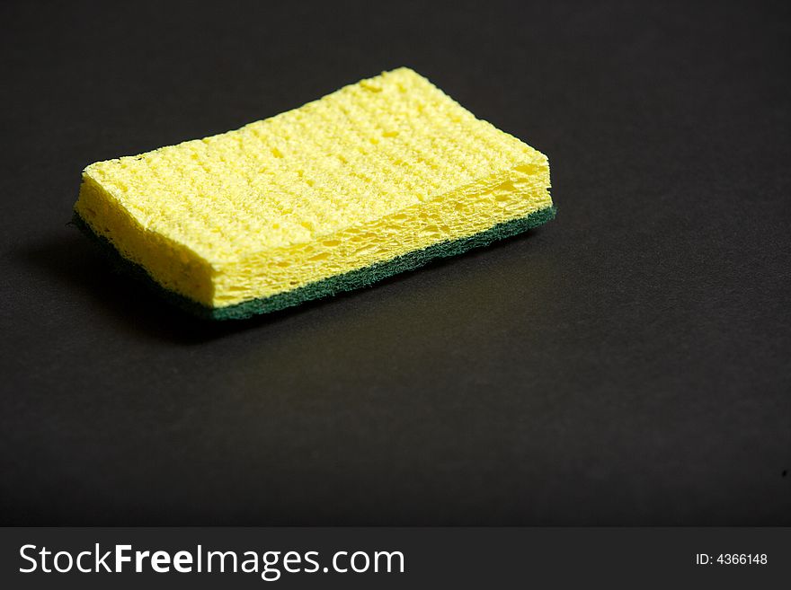 A yellow sponge on a black background