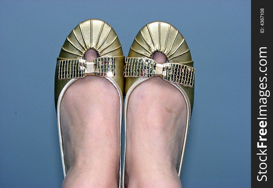 Two pretty gold shoes/slippers withs bows. Two pretty gold shoes/slippers withs bows.