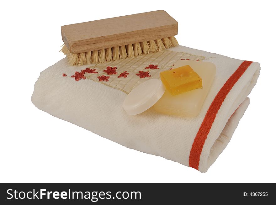 Soaps of different colors and shapes on a terry cloth towel with brush, isolated on white. Soaps of different colors and shapes on a terry cloth towel with brush, isolated on white.