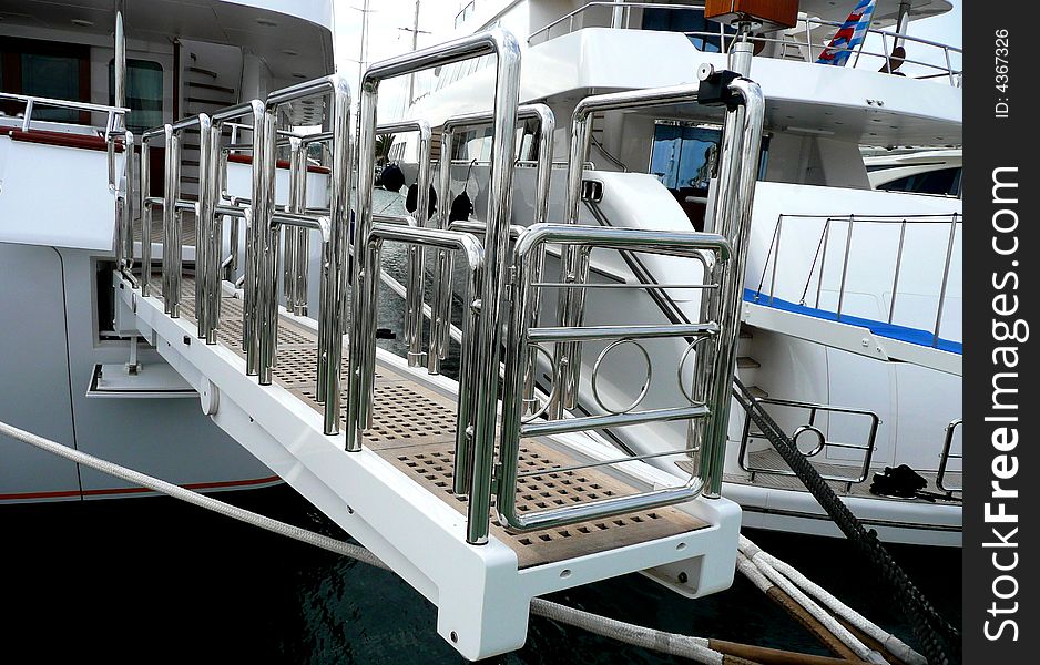 A gangplank or gangway to a boat in a marina. A gangplank or gangway to a boat in a marina