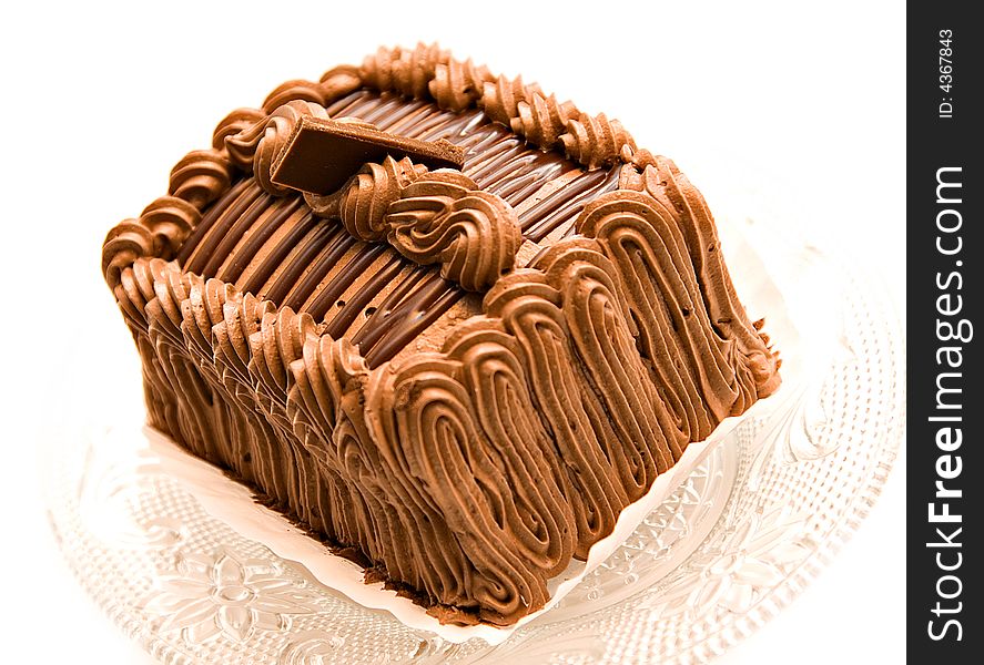 A beautifully decorated chocolate cake torte with a square of chocolate on top.