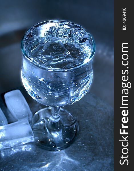 Installation with goblet of water and ice on dark background. Installation with goblet of water and ice on dark background