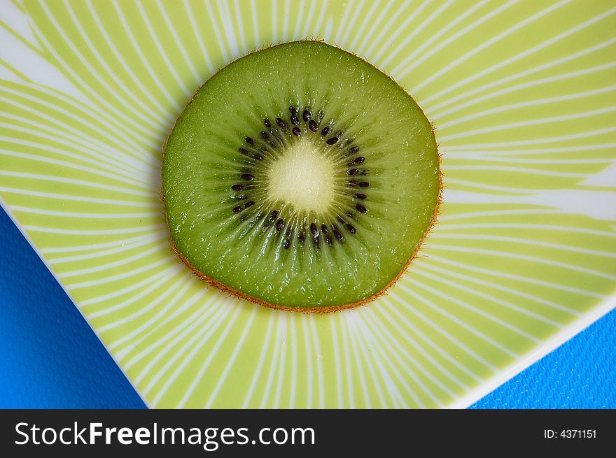 A slice of kiwi on a plate. A slice of kiwi on a plate