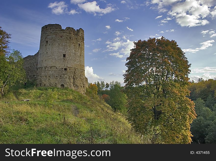 Medieval castle and green trees under blue sky with clouds. Medieval castle and green trees under blue sky with clouds