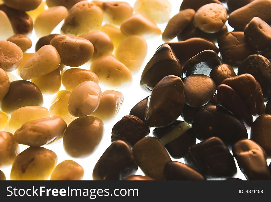 Pebbles two colors on a white background with illumination. Pebbles two colors on a white background with illumination