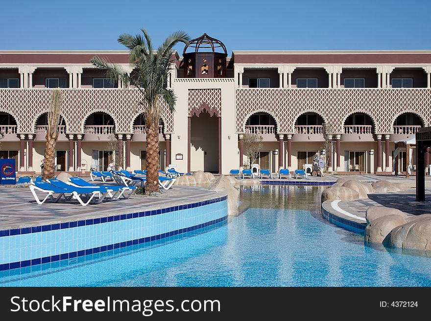 Oriental style hotel with palm tree and swiming pool