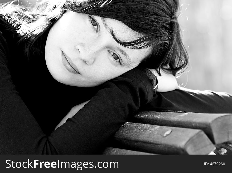 Black and white portrait of good looking woman in bench. Black and white portrait of good looking woman in bench