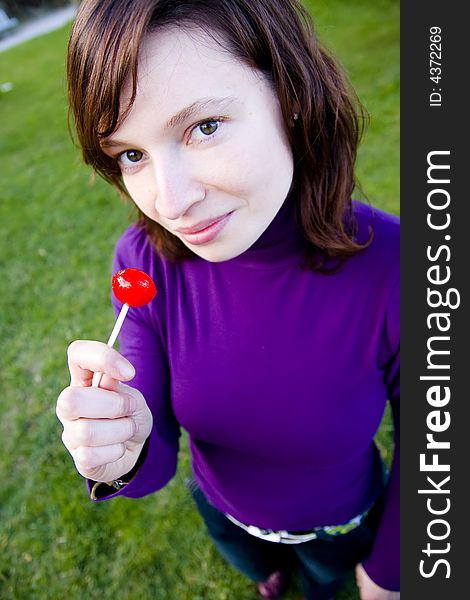 Young woman with red candy in her hands. Young woman with red candy in her hands