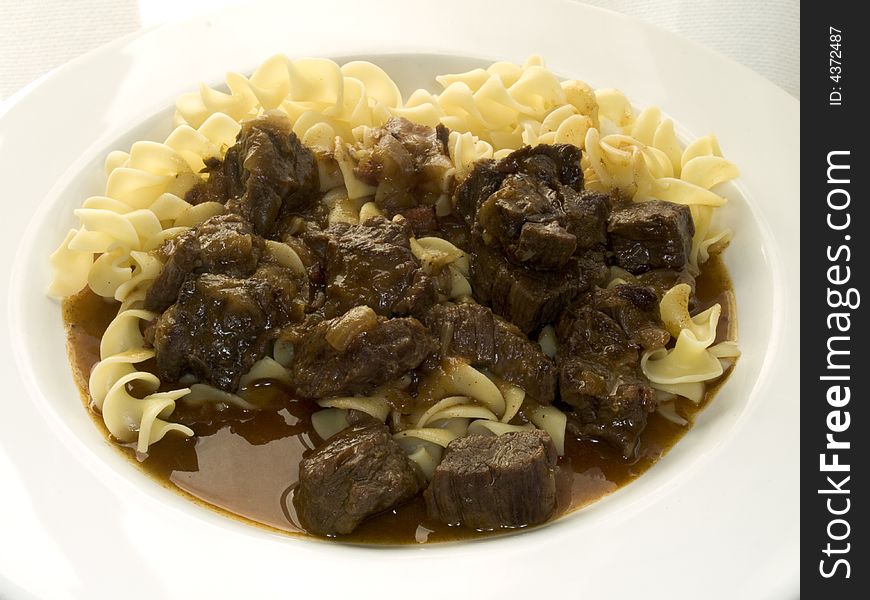 Plate with goulash and curled noodles. Plate with goulash and curled noodles