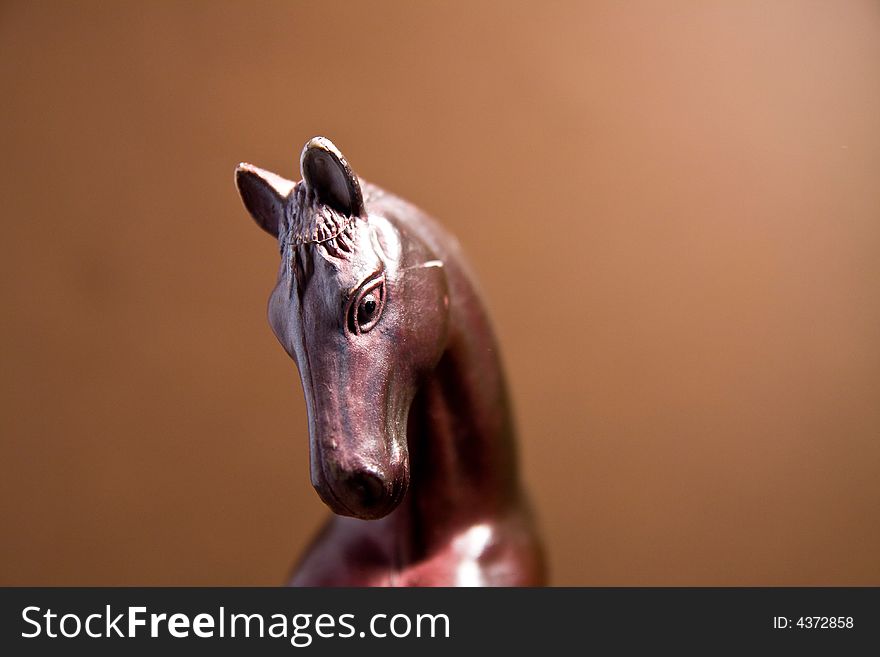 Horse head macro close up toy brown background. Horse head macro close up toy brown background