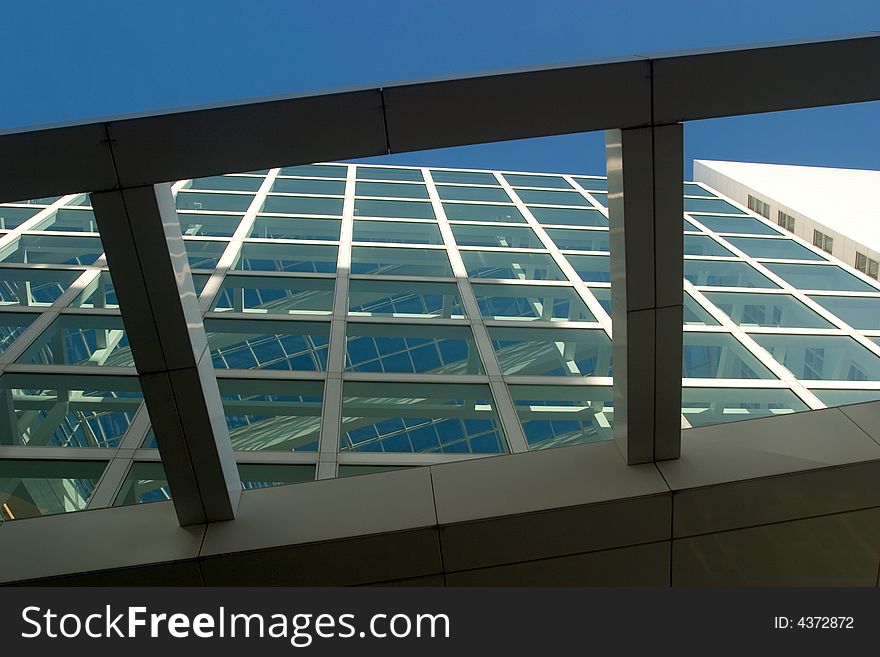 Looking through a glass wall and a glass roof towards the blue sky. Looking through a glass wall and a glass roof towards the blue sky