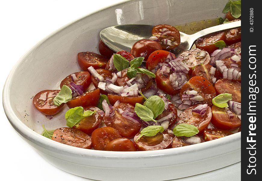 Plate full of tomato salad with basil leaves