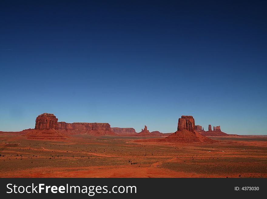 View of the red rock formations in Monument Valley with blue skyï¿½s