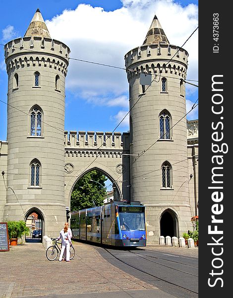 Modern tram goes between two old towers. Modern tram goes between two old towers