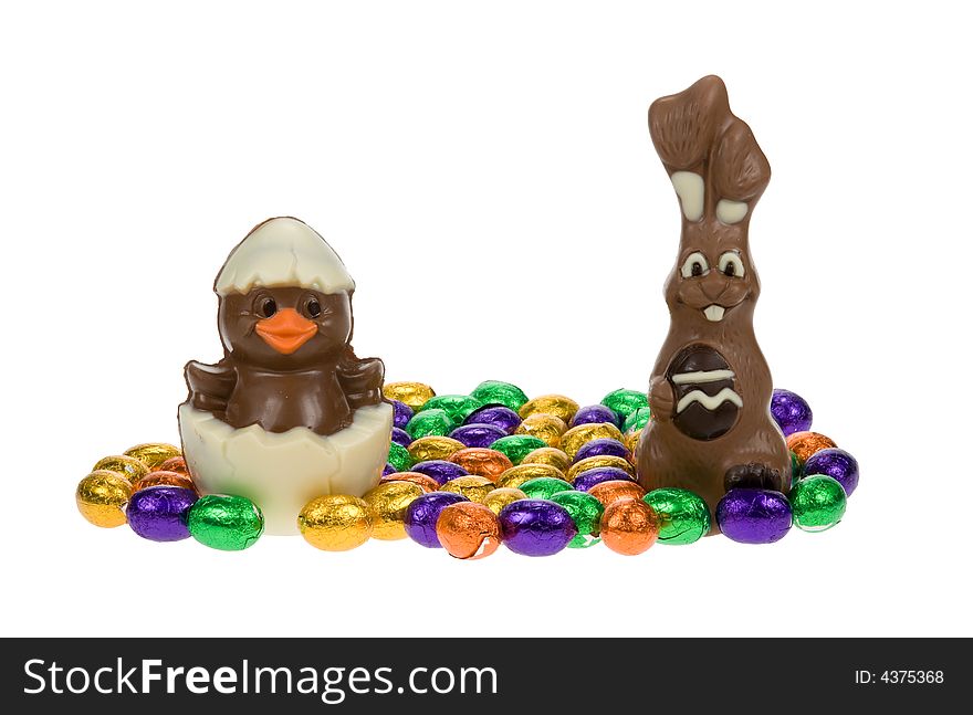 Cute easter bunny and chick surrounded by chocolate easter eggs isolated on a white background