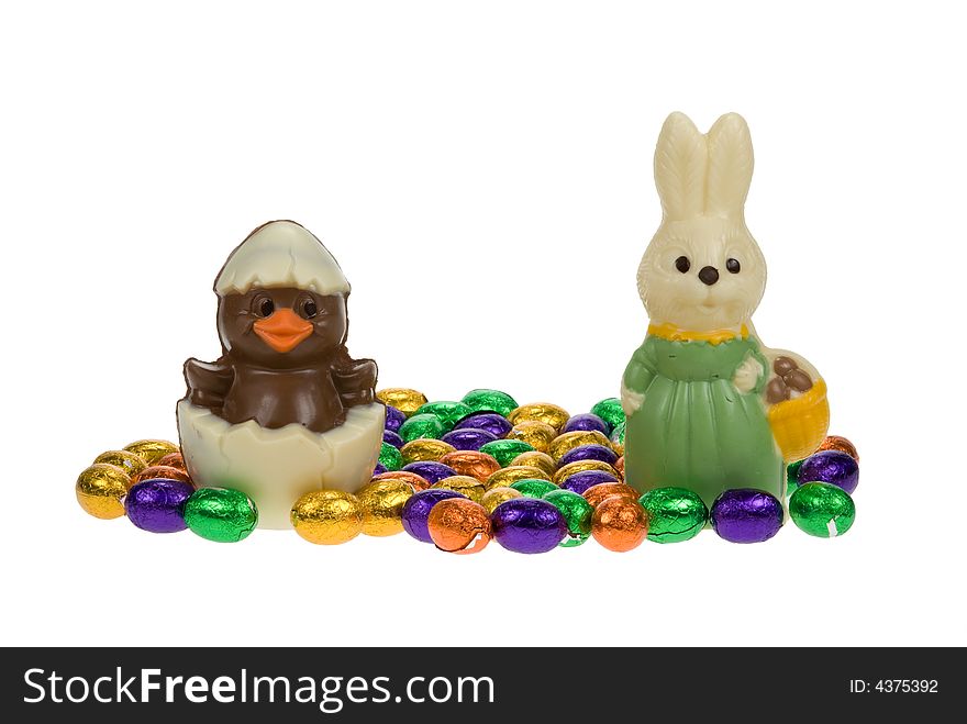 Cute easter bunny and chick surrounded by chocolate easter eggs isolated on a white background