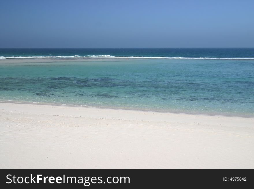 Beautiful view at sandy beach with one person standing far away in a shoal water. Australia. Beautiful view at sandy beach with one person standing far away in a shoal water. Australia.