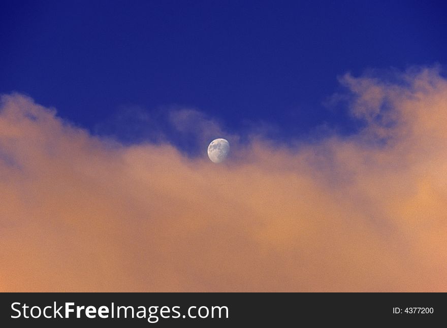 Beautiful moonrise over sunset clouds; horizontal frame