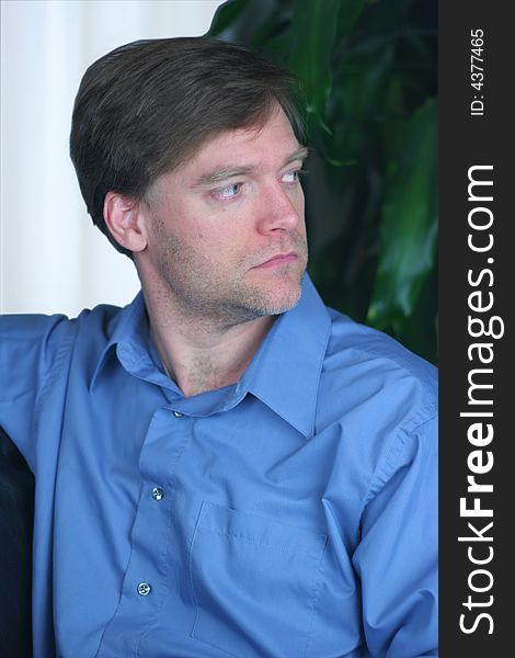 Handsome business man relaxing on couch, looking sideways