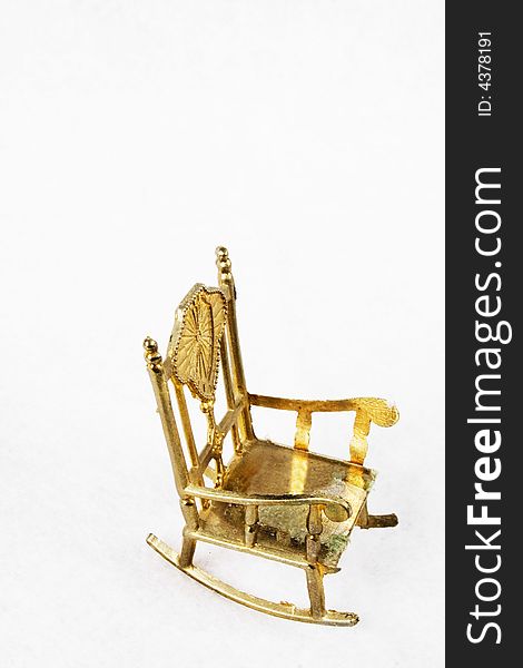 Small golden chair on a white background.