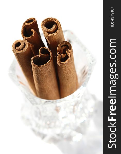 Cinnamon sticks in a crystal glass, top view, light shadow. Cinnamon sticks in a crystal glass, top view, light shadow