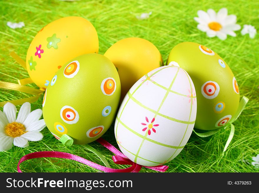 Pastel and colored Easter eggs on green