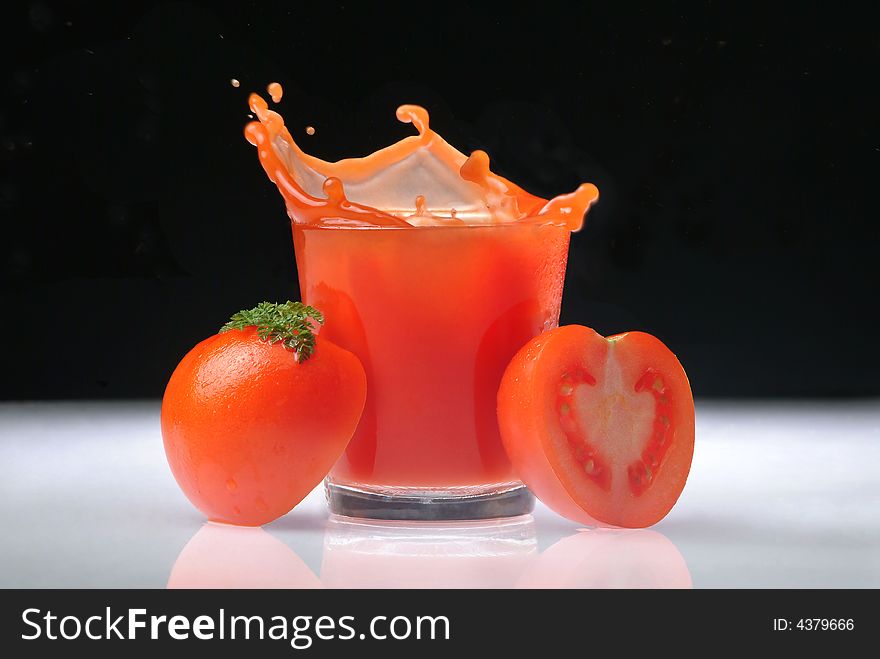 Spurting tomato juice with glass