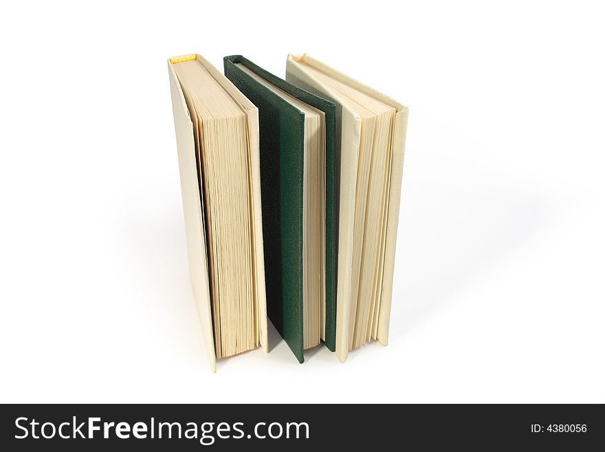 Three hardcover books standing on white background