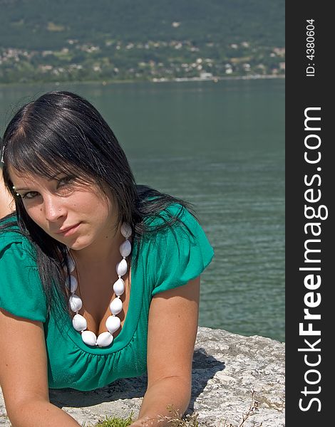 Young woman lengthened on a quay at the edge of a lake. Young woman lengthened on a quay at the edge of a lake