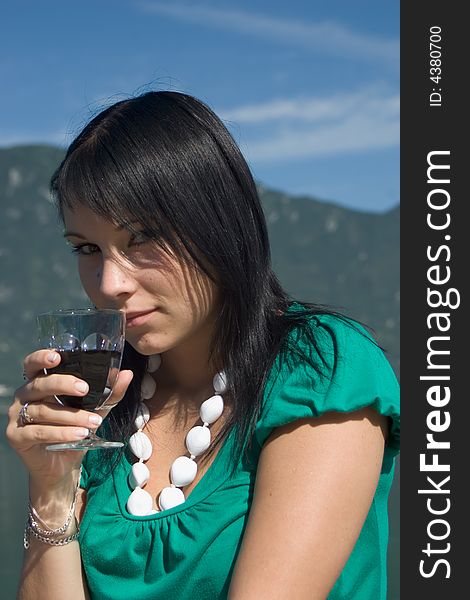 Woman tasting of the wine at the edge of a lake. Woman tasting of the wine at the edge of a lake